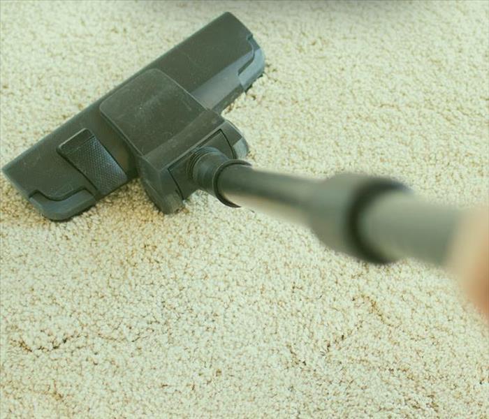 Vacuum cleaning a beige carpet